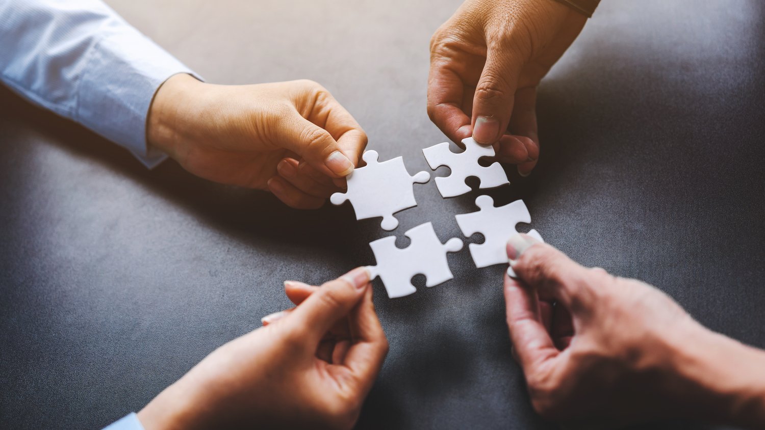 close-up-four-hands-holding-pieces-white-jigsaw-puzzle-joint-path-problem-solution-find-way-out-exit-difficult-situation-support-teamwork-concept